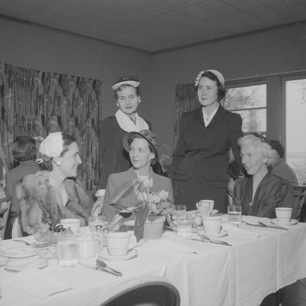 Annual Attic Angel Association, spring luncheon meeting held at the Blackhawk Country Club. Probationary members, who must complete 100 hours of work in the Association's agencies to become full members of the group, are shown. Standing, they are Mrs. Margaret (Myers) Vea (left) and Mrs. Robert B.L. Murphy (right); and sitting (left to right), Mrs. Frank Bernard, Mrs. Rachel (Johnson) Kubly, and Mrs. Dorothy Gael (Atkinson) Ela.