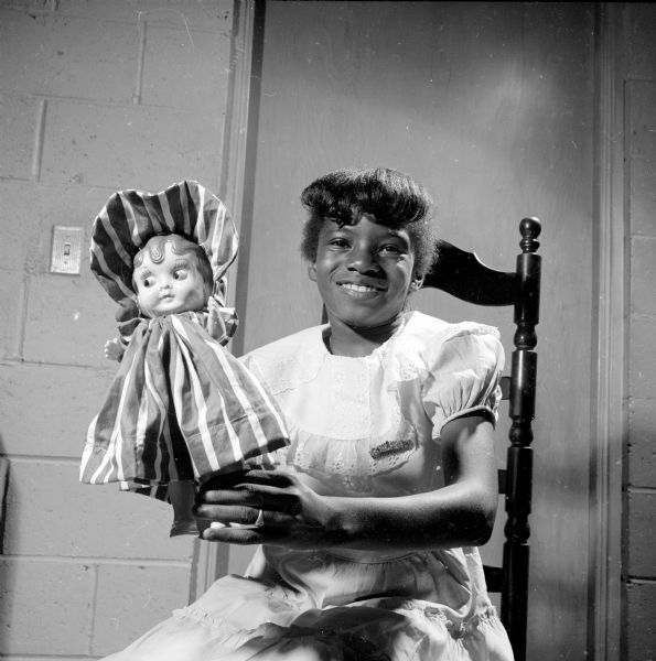 Beatrice Braton straightening the dress she made for a doll at a sewing class at Blessed Martin House. The dolls will be sent to an orphanage overseas in Japan.
