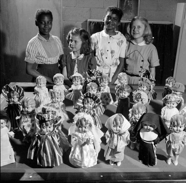 Bonita Gill, Marcia Gulrud, Jeanette Braxton, and Ann Gulrud admiring the dolls they made dresses for during a sewing class at Blessed Martin House. The dolls will be sent to an orphanage in Japan.