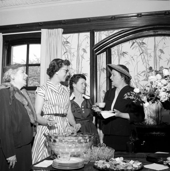 Visiting during the University of Wisconsin YWCA tea are (left to right): Mrs. H.R. English, Alice Niebuhr, Mrs. Kenneth Little and Francis Brewster. They are standing around a punch bowl.