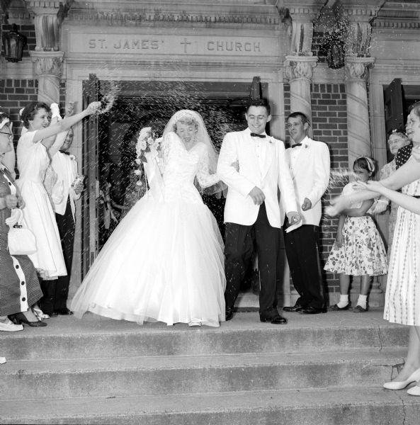 Marion Chitwood and Leroy Billings exiting St. James Church after their wedding. The couple is met with guests throwing rice in the air. 