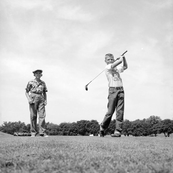 Portrait of golfers, Emerson Moran and Brad Walrath, to make a composite image that was published in the newspaper of them at Maple Bluff Golf Course with an enlarged golf ball. Moran (left) is yelling "fore" as Walrath is getting off a drive with a "ball that looks like it needs an airfield for a fairway."