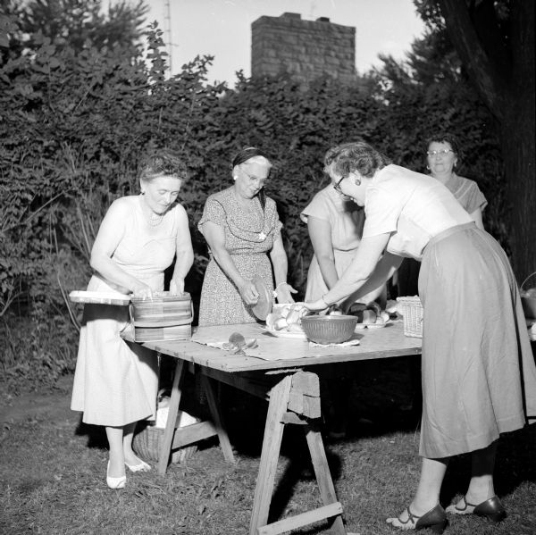 City Hall Outing hostess, Alderwoman Ethel Brown (left) is shown laying out a picnic meal with help from Mrs. Norman Moll and Mrs. Lawrence McCormick. The outing was held at Alderwoman Brown's summer home on Lake Mendota's north shore near Borchers Beach.