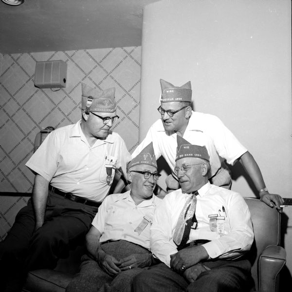 Three new grand officers of the Wisconsin American Legion's 40 and 8 talking with Julius Severson (right foreground), retiring Grand Chef de Gare. At left are Jack D. Wilson, Milwaukee correspondent, and Dr. G.F. Garrigan, new Grand Chef de Gare. At right is Robert A. Cuthbert, Chef de Gare de Train. The new officers were installed at a 40 and 8 Convention session at the Elks Club.