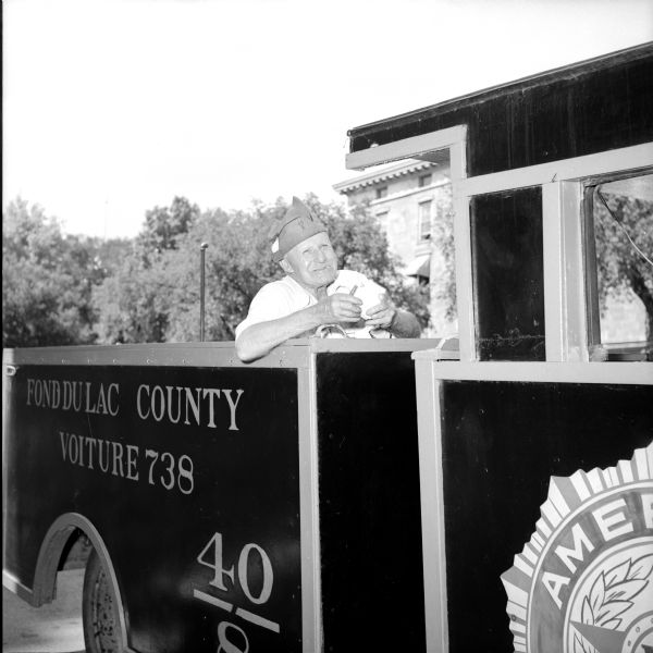 Edward H. Vogt taking a bite out of his sandwich aboard his American Legion Voiture's "locomotive," number 738 for Fond du Lac County.