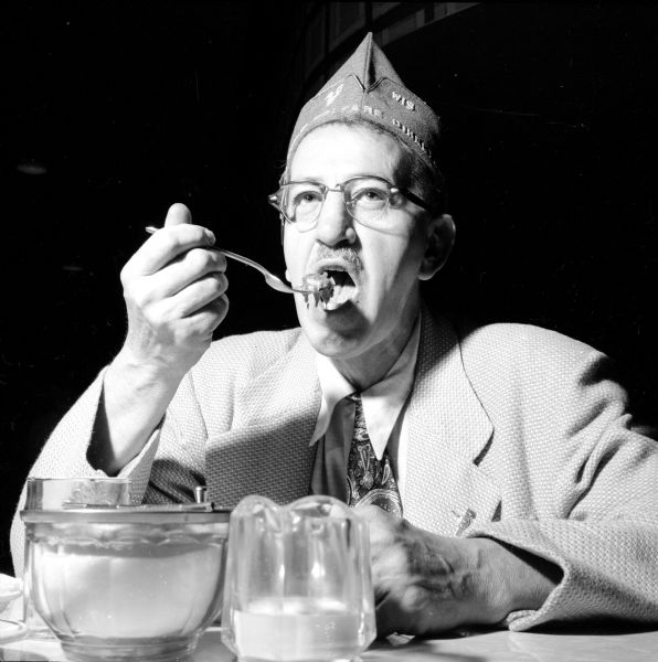 Everett C. Gerry, Wisconsin National Gurad 40 and 8 Child Welfare Director, is shown eating a meal at the convention, held in the Elks Club.