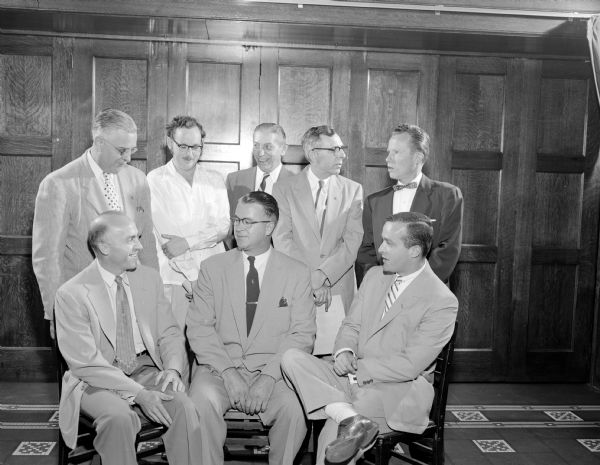 Group portrait of eight men at a meeting of Madison Newspapers, Inc., the publisher of the <i>Madison State Journal</i> and <i>Capitol Times</i>. 