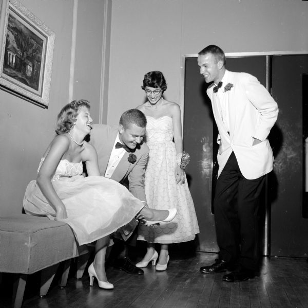 Two couples taking a break from dancing at the university summer prom at the Memorial Union. From left to right are: Jaqueline Wilson (of Worcester, Massachusetts); Bob Lowell (of Crystal Lake, Illinois); Margaret Gruenewald (from Sheboygan); and Robert Cope (of Cambridge, Massachusetts). Margaret is wearing a corsage on her wrist.