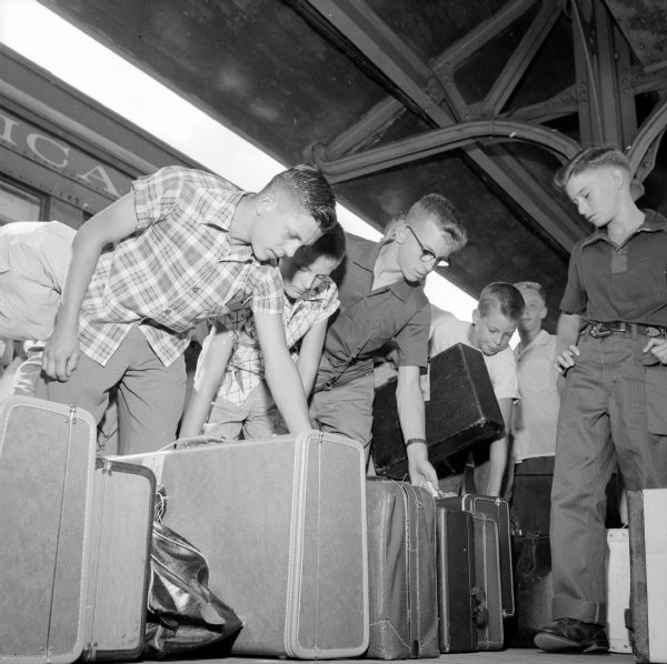 Seen left to right are Madison Newspapers Inc. newsboys Richard Klinger, Mike Campbell, and Chuck Misky (all from Platteville) and Tom Blanchard (of Poynette). Standing on the train platform, they are grabbing their suitcases before boarding the train for a week in the nation's capitol.