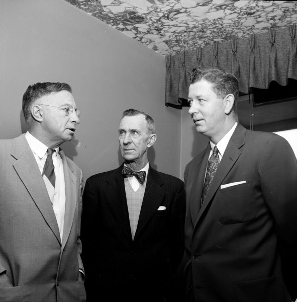 Representatives of business, labor and government meet at the Edgewater Hotel for a pre-luncheon gathering to celebrate the opening of a new Sears store. Standing left to right are: Louis Gardner, Gardner Baking Co.; Pearce L. Roberts, Madison Building and Construction Trades council; and Alderman Lyle Andrews, president of the Madison City Council.
