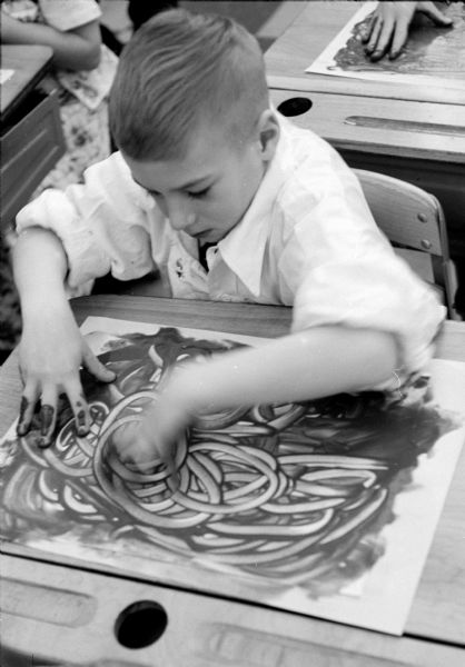 Third-grade student Peter Stravinski (of 4910 Rothman Place) working on a finger painting project at Nichols School.