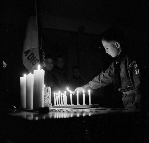 Boy Scout Lloyd Dresen lighting a candle during the investiture service at Lakeview Community Church. The church is sponsoring Madison's newest Scout Troop - number 109.