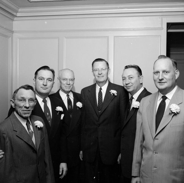 Annual banquet of the East Side Business Men's Association (ESBMA) held at the Loraine Hotel. Shown left to right are past-presidents of the organization: John Niles, 2137 Sommers Avenue; Ray Lease, 1634 Sherman Avenue; Marshall Browne, 1442 Morrison Street; Herbert J. Schmiege, 1824 Yahara Place; Irv Goff, 509 Maple Avenue; and E. P. Lorenz, 2129 Lakeland Avenue. All the men are wearing a single white carnation as a boutonnière on lapels. 