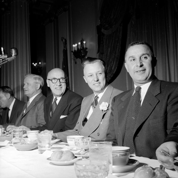 Annual banquet of the East Side Business Men's Association held at the Loraine Hotel. Shown at the speaker's table from left to right are: L.L. Lunenschloss, 418 Marston Avenue, Security State Bank president; Dewey Badeau, 1618 Yahara Place, ESBMA president, wearing a carnation boutonnière on his lapel; and Mike Tripalin, 166 Talmadge Street, ESBMA vice-president. The two men on the far left are unidentified.