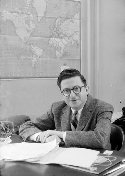 Morris Rubin, editor of <i>The Progressive</i>, sitting at his desk decked with a glass ashtray with cigarette, matchbook, and papers. In 1940, Rubin (b.1911-d.1980) became editor of the liberal magazine published in Madison. It was founded in 1909 by Robert La Follette, Sr.