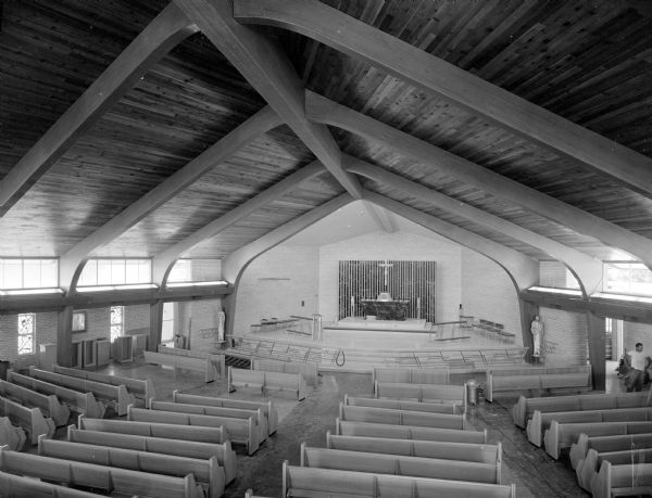 Interior elevated view of the sanctuary and nave full of pews from the choir's balcony in the new Our Lady Queen of Peace Catholic Church at 401 South Owen Drive.