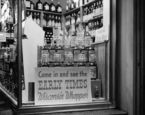 Early Times liquor display in the window of Riley's Capitol Liquor Store at 328 State Street. The display sign: "Come in and see the Early Times Wisconsin Whopper" is standing in front of Early Times bottles and glasses.