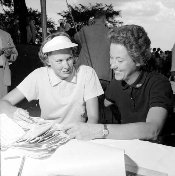 A professional and an amateur paired up for the 26th Annual Women's Western Open golf tournament at the Maple Bluff Country Club. Mickey Wright from LaJolla, California, on the left wearing a visor, set the pace for the first 36 holes. Her partner, Jean Hopkins from Rocky River, Ohio, on the right wearing an Izod shirt, failed to make the title flight.