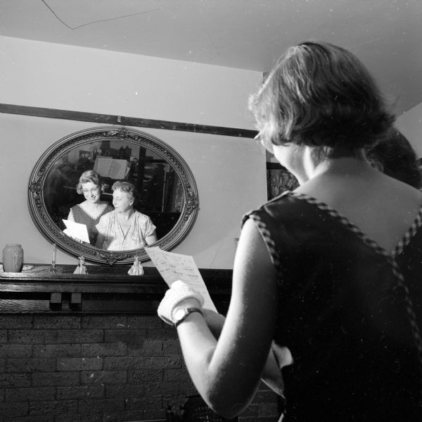 Mary Kate Lorenz and Mrs. Arthur F. Carey reflected in a mirror, holding two season tickets for the Madison Theatre Guild.