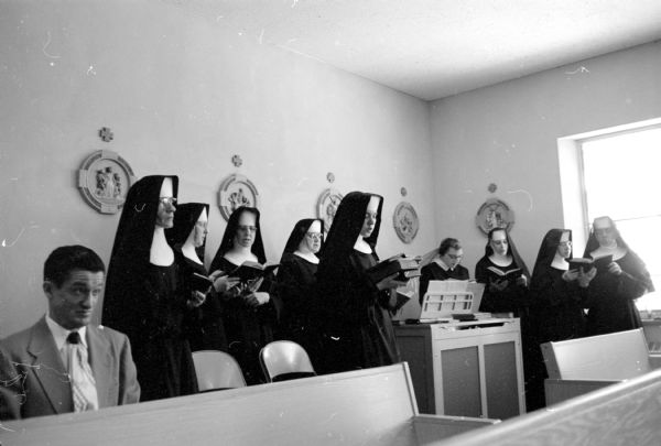 A group of Benedictine nuns singing as the choir at the solemn high Mass of Thanksgiving in their small chapel at their new mother-house located on County Highway M near Fox Bluff.