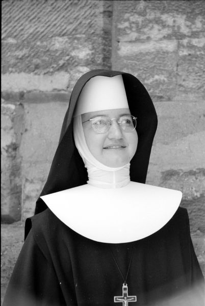 Attending a convocation session of the Wisconsin Congress of the Confraternity of Christian Doctrine at St. Raphael Cathedral is Sister Mary Justa of the School Sisters of St. Francis in Lancaster, Wisconsin. She is wearing a wimple under a black veil.