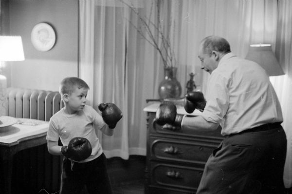 University of Wisconsin artist-in-residence, Aaron Bohrod, boxing with his son, Neil (8-years-old), at his home located at 715 East Gorham Street.