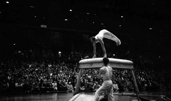 A Swedish gymnast performing his high table vaulting act. The Swedish national men's and women's teams putting on their gymnastic show at the U.W. Field House.