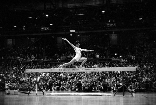 Mrs. Marie Hosely from Monroe performing on the balance beam during the gymnastics show by the Swedish national men's and women's teams at the U.W. Field House. She was a member of the U.S. Olympic team in 1952.