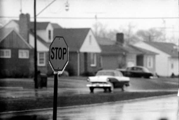Rain in the street, and an arterial stop sign at Wakefield Street and Midvale Boulevard, with icicles hanging from the bottom of the sign.