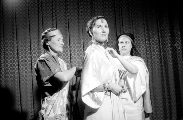 The Madison Women's Club presents the original play "Man and His God" to raise money for scholarships. Depicting the conversion of Izeyl to Buddhism (left to right) is: Mrs. Floyd Schwartz of 2313 Hoard Street as an attendant; Mrs. Carroll Holtz as Izeyl; and Mrs. William Zurian of 610 Glenwood Road as an attendant.