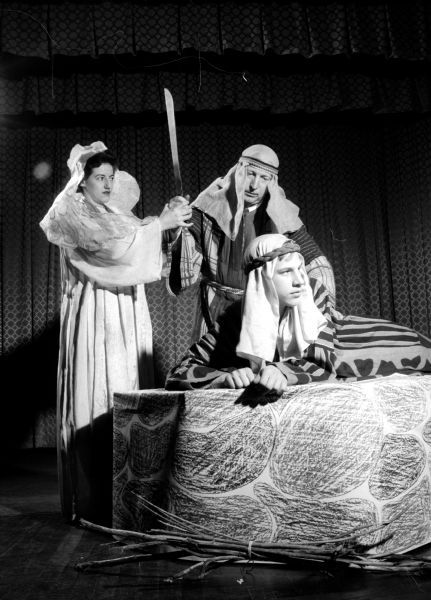 Madison Women's Club presents the original play "Man and His God" to raise money for scholarships. Shown depicting the sacrifice of Isaac by Abraham (left to right) are: Mrs. James Anderson of 1212 Chandler Street as an angel; R.H. Brigham of 2814 Lakeland Avenue as Abraham; and Bruce Beck of 4161 Hiawatha Drive as Isaac.     