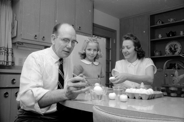Coloring Easter eggs at their kitchen table are Sherry Svee, age 8, with her mother, Melba Svee, and father Kenneth Svee who is executive director of the Madison Easter Seal Society.