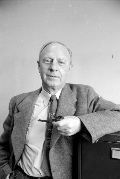 Portrait of Professor Norman P. Neal, Village President of Shorewood Hills, holding a tobacco pipe.