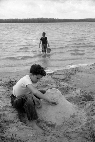 Keith Symon of 1816 Vilas Avenue (front) and John Hunt of 1813 Vilas Avenue (rear) building a sand castle at the Vilas Park beach on a spring day.