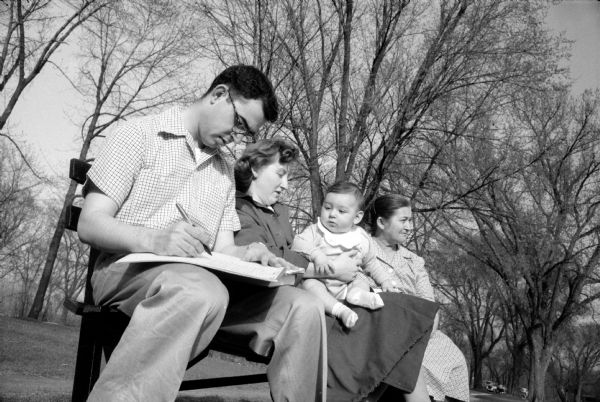 Law student George Stephan, 403 N. Murray Street, studies at Tenney Park while his wife, infant son, and mother-in-law, Mrs. Hofmeister, enjoy the sunshine.