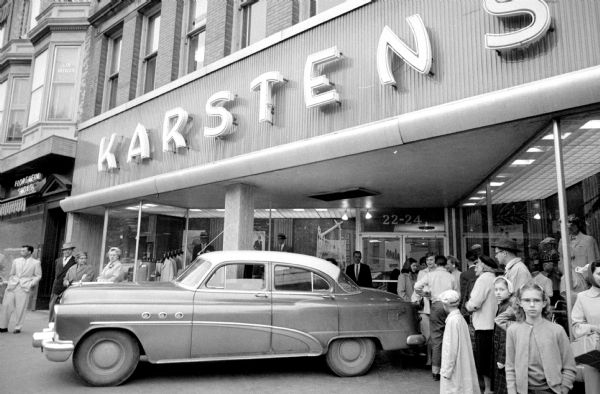 A parked Buick Super sitting in front of the Karsten's men's shoe store on Carroll Street on the Madison Capitol Square. It had rolled across the street and was stopped by three men before it reached the storefront's plate glass window. The driver, Mrs. Emil Faust, reclaimed her roving vehicle later.