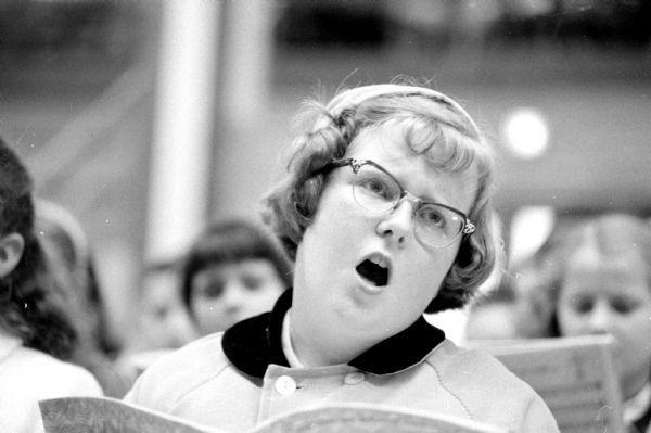 The 24th annual Radio Music Festival of the WHA Wisconsin School of the Air held at the U.W. Stock Pavilion attended by 2,019 boys and girls. Margaret Merlet (of Beloit) typifies the singers attending the event. The concert was broadcast live over WHA radio.