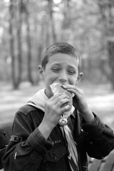 Scout Paul Capadona (1214 Drake Street) happily consumes a hot dog and bun. He is a member of Cub Scout Pack #321, Den #6 picnicking at Hoyt Park. 