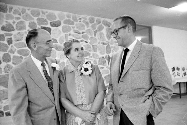 The retiring general secretary of the Madison YMCA, Loren Cockrell, and his wife Margaret, are greeted by the man who will succeed him, William Schultz (right), at the retirement party for him at Camp Wacanda.