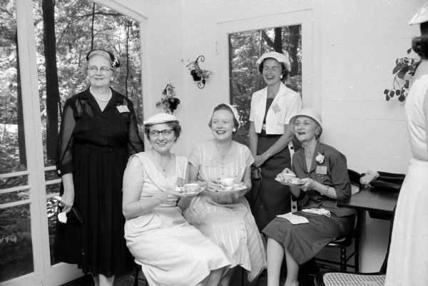 Members of the PEO (Philanthropic Educatinal Organization) Reciprocity Board hold a tea in honor of First Lady Helen (Davis) Thomson, wife of Wisconsin Governor Vernon W. Thomson, and Mrs. A. E. Hatch (Fond du Lac), State PEO president. At the tea held in a Maple Bluff residence are (left to right): Mrs. Bryan Wilson (1610 N. Sherman Avenue); Mrs. Florence Lawrenz (3500 Topping Road); Mrs. Arthur Olson (Middleton); Mrs. John E. Wise, Jr. (5318 Frosty Lane); and Mrs. Edward Rounds (4125 Winnemac Avenue).