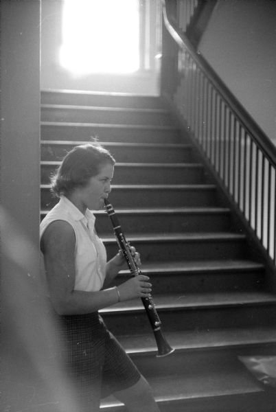 Pat Harley of East Troy, Wisconsin, is practicing her clarinet in the stairwell during the 1957 Summer Music Clinic on the University of Wisconsin campus.