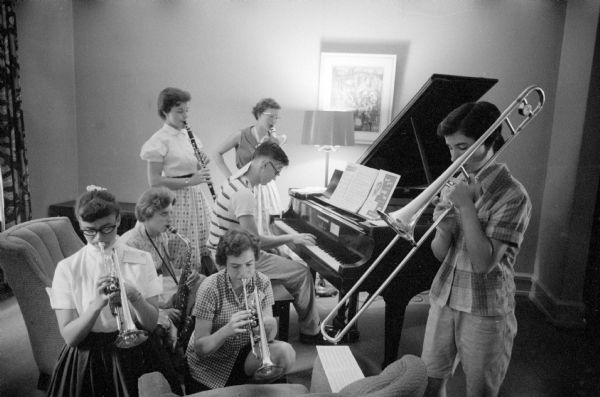 Six participants of the Music Clinic in University of Wisconsin's Bernard Hall are shown in a jam session. They are the "Dixie Landers" playing "As the Saints Go Marching In" on piano, trumpet, trombone, saxophone and clarinet.