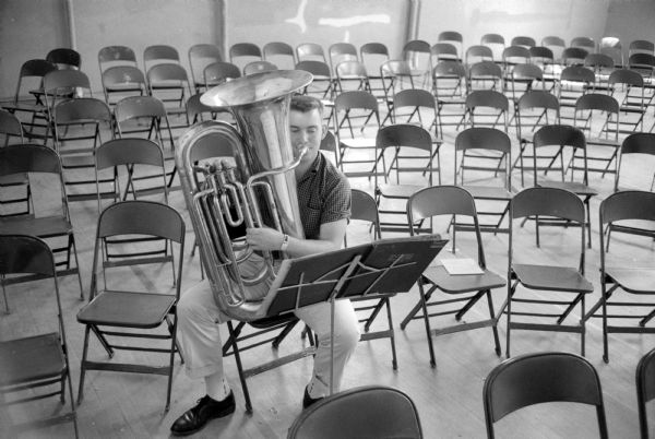 In a room full of empty folding chairs, John Braunschweig practices his tuba during the Summer Music Clinic at the University of Wisconsin. He is one of 783 participants.