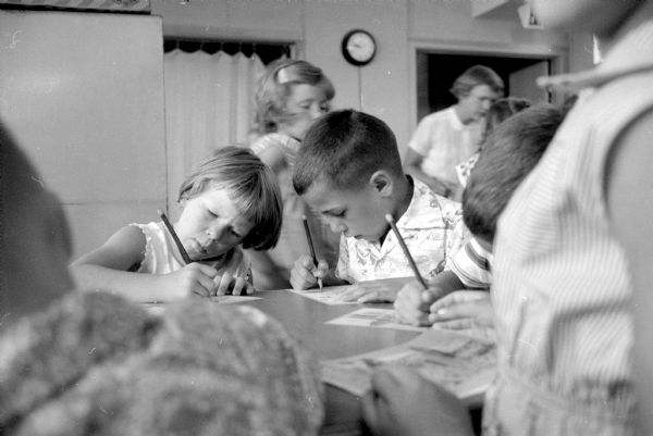 Children attend the summer Bible school session at Midvale Community Lutheran Church at 4329 Tokay Boulevard. Shown doing an art project are (left to right): Beth Bokelmann (337 Orchard Drive) and Larry Smith (521 Woodside Terrace). 