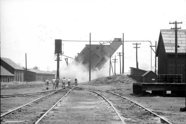 North Western Railroad employees demolish a concrete coal chute at the railroad's East Side yard, at Commercial and Sherman Avenues, on their second attempt. The first attempt the day before failed to demolish the chute.