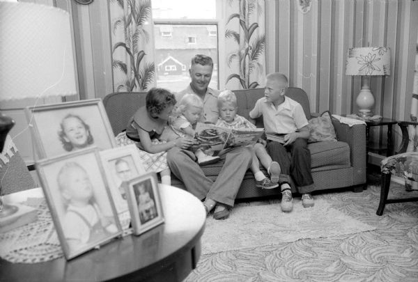 Orlow R. Notstad reads to his four children in their farm home near Cambridge. His two oldest, Jimmy and Barbara, will be elementary students at the Rockdale School the day after Labor Day.