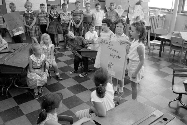Three pupils at the Washington School report on Indian ceremonies to the third grade at the end of the University of Wisconsin Summer Lab School. Holding their own newspaper titled: Indian Ceremony Reporter, are (left to right): Mary Anne Knechtges, Jean McNeel, and Jeanne Burgess. Not shown, their teacher is Julia Steinke.
