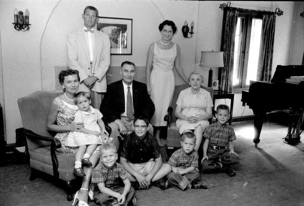 Thomas E. Jones family portrait at their home on Chadbourne Avenue. Standing are their son and daughter, E. Thomas Jones and Mrs. Elizabeth Thomas. Darcey Jones is on her mother's lap next to the senior Jones's, who are also sitting. On the floor are (left to right): Scot Jones, Dick Thomas, and Rex and Tommy Jones.