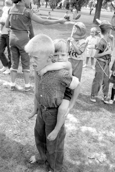 Mickey Toseff, 10, gives his brother Jeff, 3, a piggy-back ride at the Truax Field Playground Costume Party.
