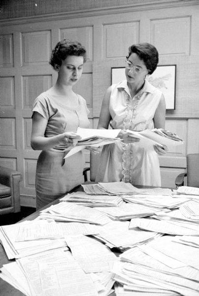 Looking through hundreds of entries received for the <i>Wisconsin State Journal's</i> cookbook recipe contest are Jo Ann Beier (left), WSJ women's editor, and Dolores Walker, secretary to WSJ's publisher.